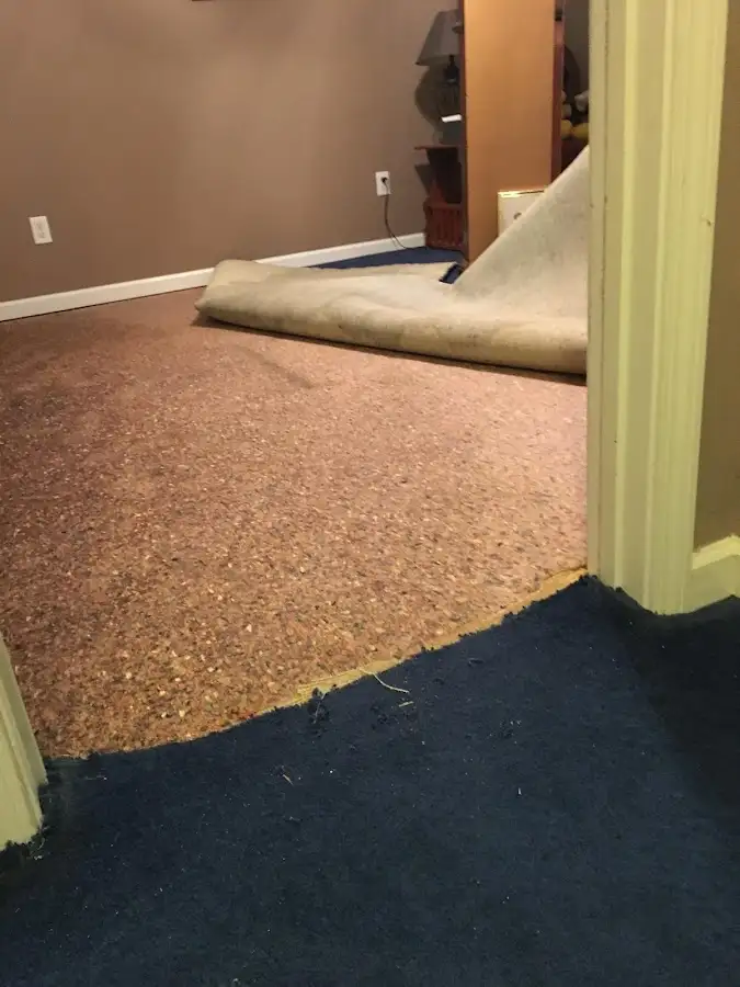 Carpet pad removal revealing water damage during Water Mitigation Services in Coffeyville